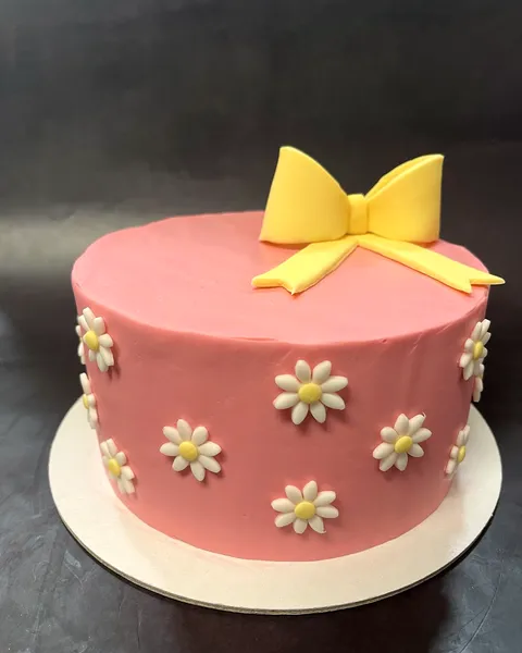 Tarta rosa con margaritas y lazo