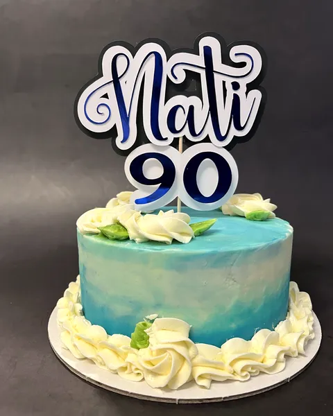 Tarta azul con rosas de crema y el 90
