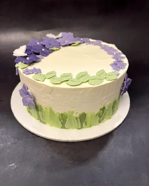 Tarta con flores lilas y hojas verdes