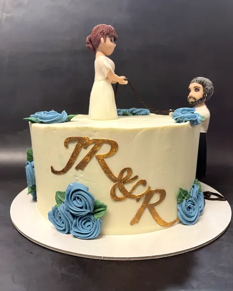 Tarta de boda con figuras de novios y rosas azules