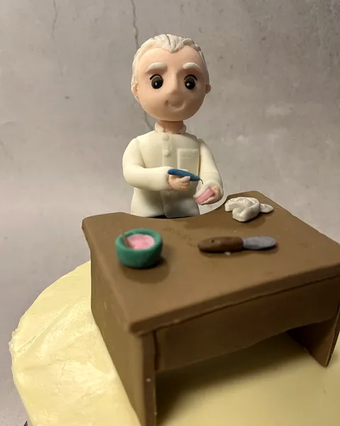 Hombre con bata blanca en su mesa de fondant