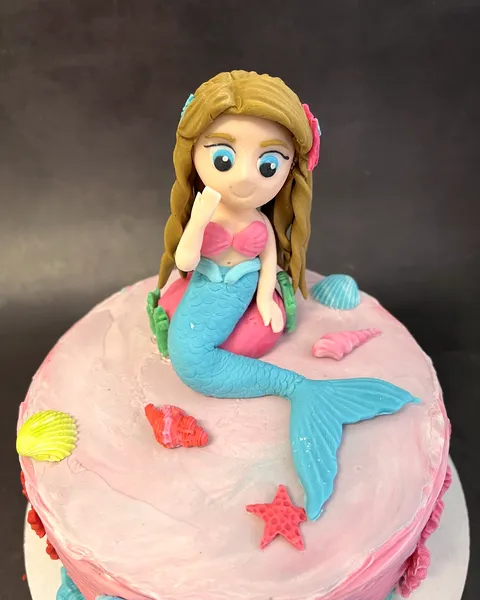 Sirena de fondant sobre tarta rosa