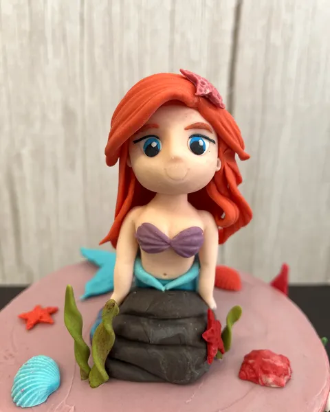 Ariel de fondant sobre tarta rosa