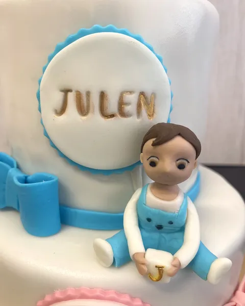 Bebé de bautizo con peto azul de fondant
