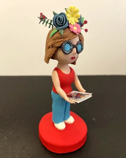 Chica con corona de flores leyendo de fondant