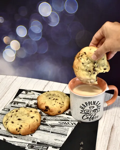 Galleta con pepitas de chocolate mojada en café